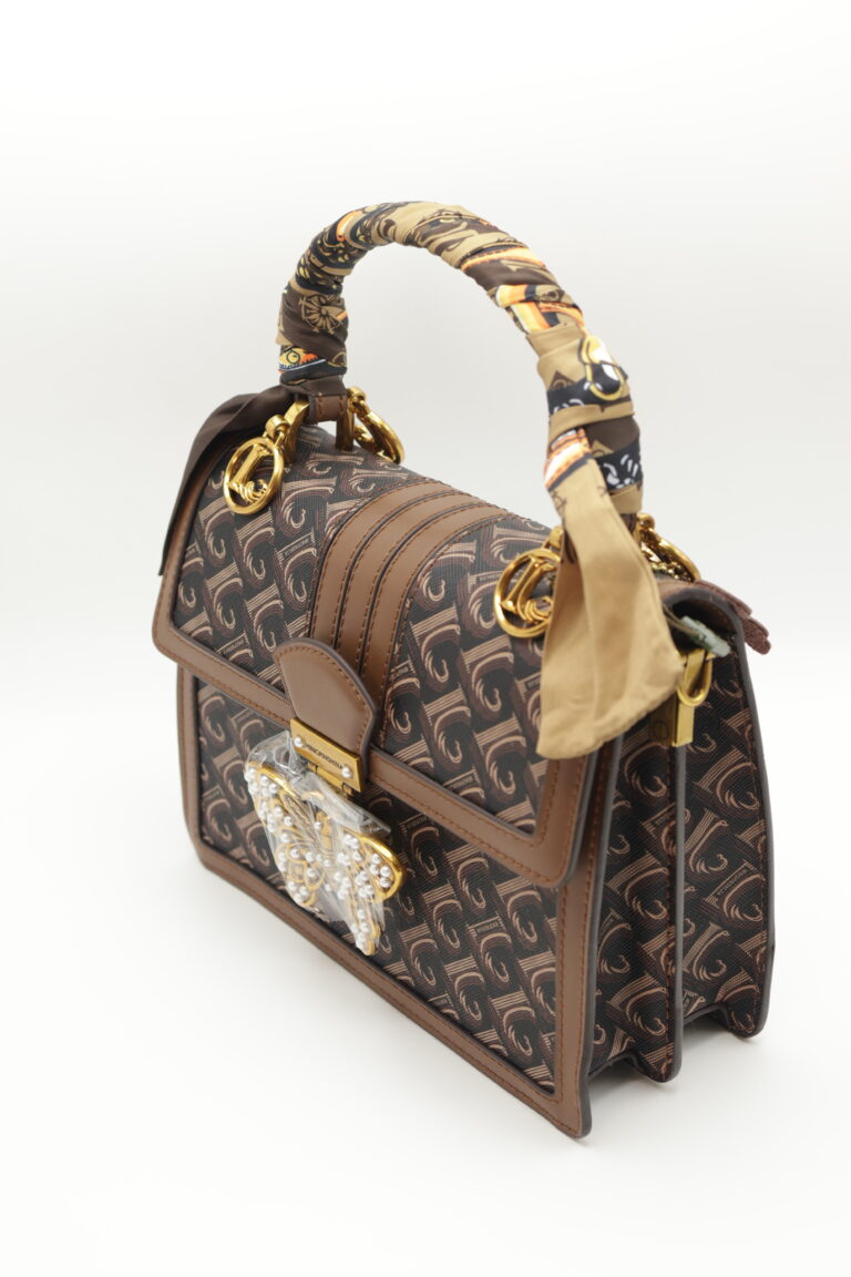 Image 2 of 5 — angled front three-quarter view of the Chocolate Butterfly Luxe Bag showing the depth of the body and the flap edge