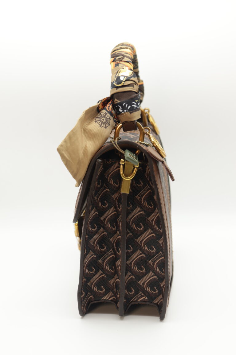 Image 3 of 5 — side profile of the Chocolate Butterfly Luxe Bag showing the gusset depth, monogram side panel, the gold clip of the detachable shoulder strap and the twilly scarf tail